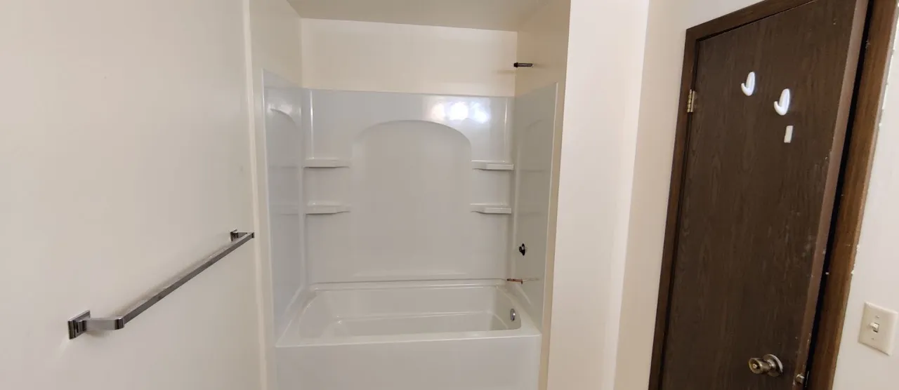 Bathroom with a new tub and one-piece shower surround installed