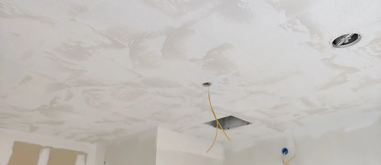 Ceiling drywall repaired and finished with recessed light openings cut
